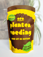 Kamerplantenvoeding van schapenwol: ORO wolkorrel 400 gram naast een graslelie in pot